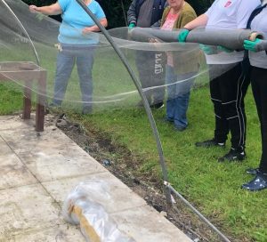 Service users of Old Tree Nursery installing ClearMesh onto poly tunnel